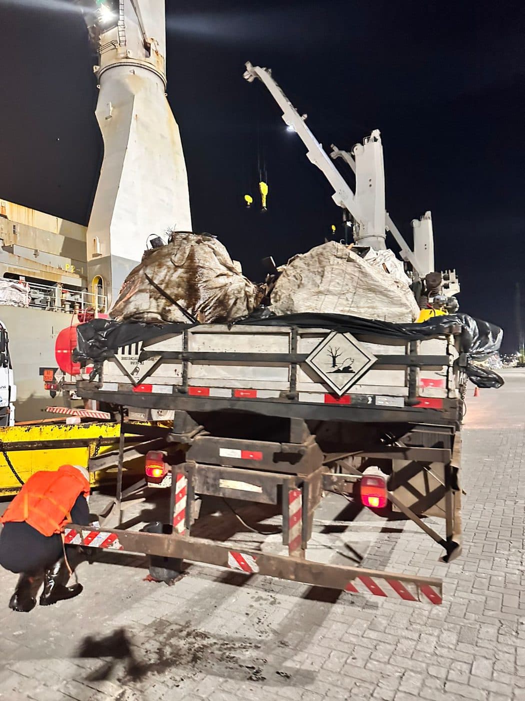 Night-time waste loading operation at the port with a crane